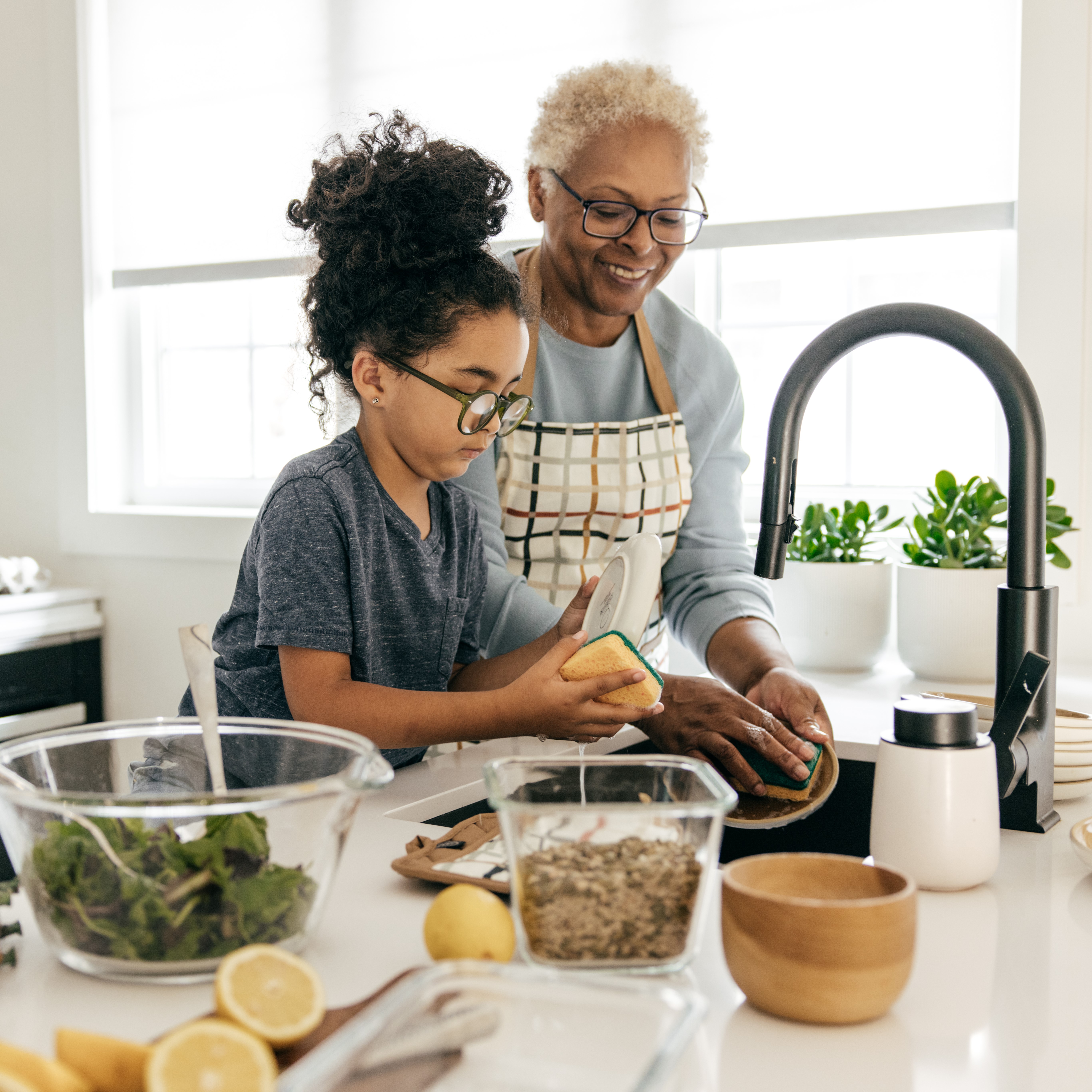 Child and grandmother cooking together in kitchen