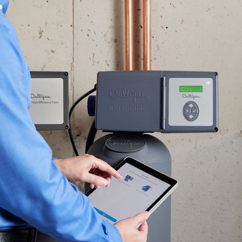 Culligan employee using tablet to operate water softener