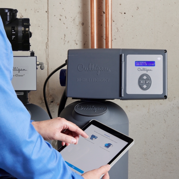 Culligan employee operating water filter with tablet