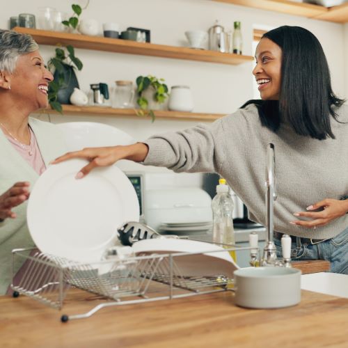 Mother and daughter wash dishes with softened water.