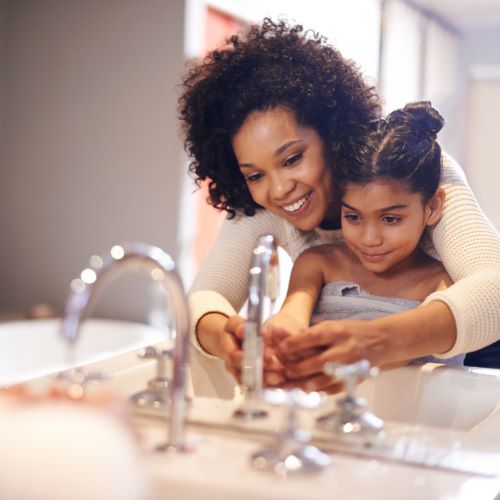 Mom and daughter washing hands with clean well water
